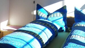 A room with a bed, pillows, a wall-mounted lamp, and a framed picture. - Morgenstern Appartement/Fewo, Dusche, WC, 1 Schlafraum 4-Bett-Wohnung by Interhome (St Stephan)