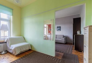 A room with a bed, a mirror, a sofa, and a cabinet. - Szczecin Old Town Standard Apartment (Szczecin)