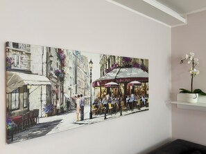 A painting of a café scene with outdoor seating and a street view.