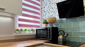 Eine Küche mit eingebautem Toaster, einem Wasserkocher und einem Fenster mit Jalousien.