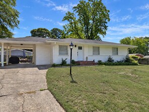 A single-story house with a covered porch, a front lawn, and a street lamp. - Spacious 3BR Home Near Truist Park and I-75 (Marietta)