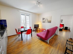A modern living space with a dining area, a sofa, a TV, and a kitchen. - Apartment  by Interhome (Zurich)
