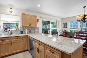 A kitchen with wooden cabinets, a marble countertop, and a dishwasher. - Duplex in Family Neighborhood - Easy Parking - On Ski Bus Line (Steamboat Springs)