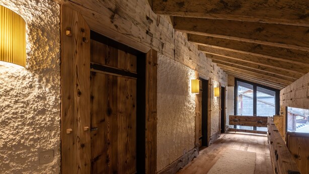 Ein Holzflur mit einer großen Tür und Wandleuchten.