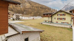 A residential area with houses, a sports field, and a mountain backdrop. - Haus Astoria by Interhome (Saas-Grund)