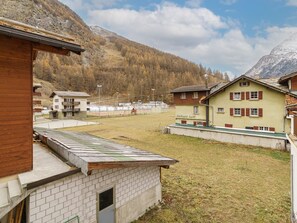 Ein Wohngebiet mit Häusern, einem Sportplatz und einem Berg im Hintergrund.