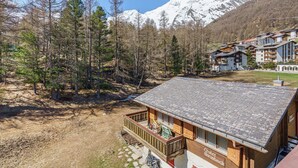 A chalet with a wooden deck and a sign reading 'Chalet Steinbock.' - Haus Alfa by Interhome (Saas-Fee)