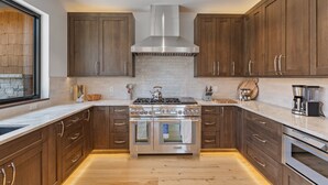 A modern kitchen with wooden cabinets, a stainless steel range, and an oven. - Mountain-view Avon townhome with 3 bedrooms, hot tub, fireplace, and deck. (Avon)