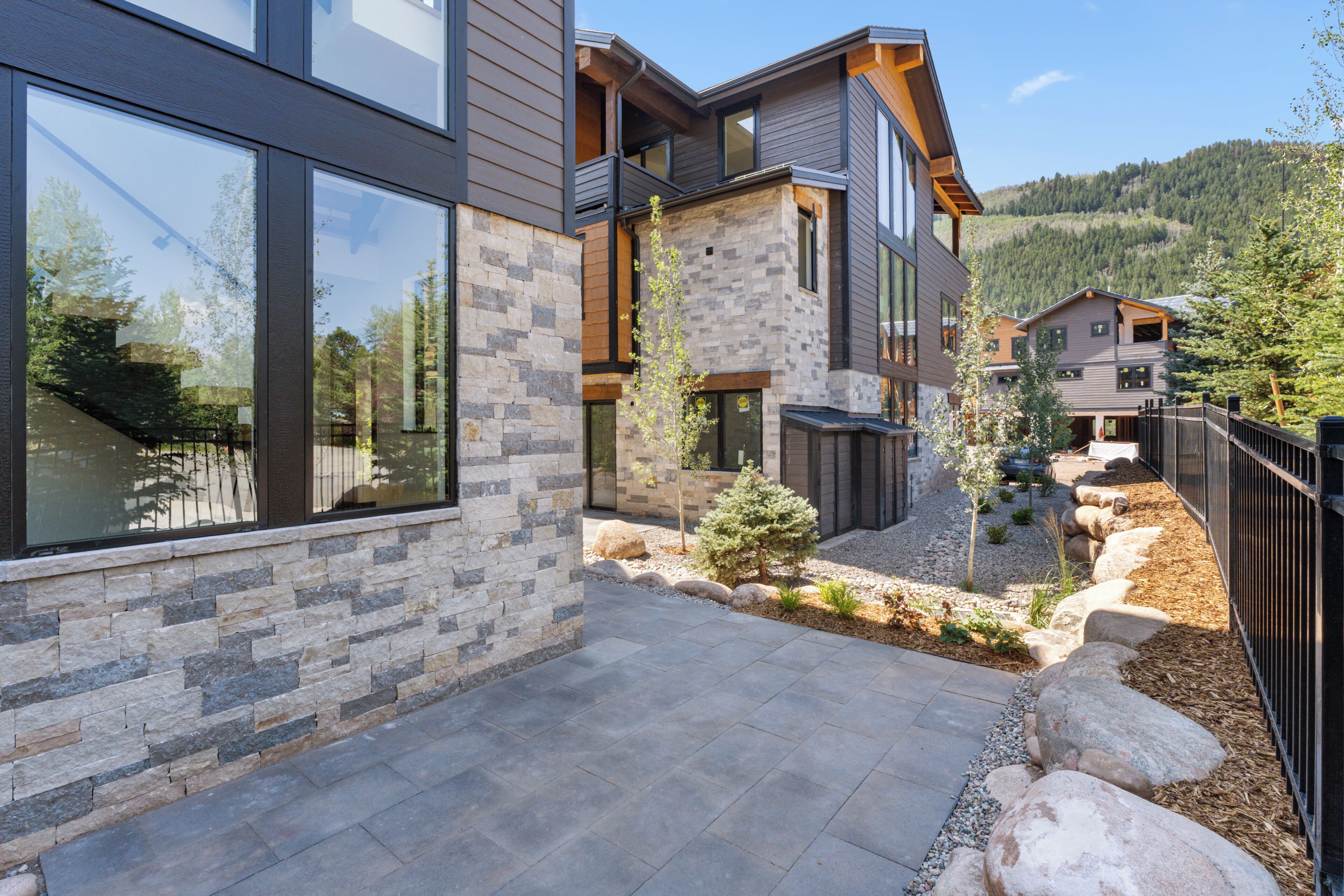 A modern multi-story building with large windows and stone accents.