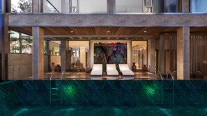A modern spa area with a pool, lounge chairs, and a colorful wall art installation. - VP Sisaked Hotel (Vientiane)