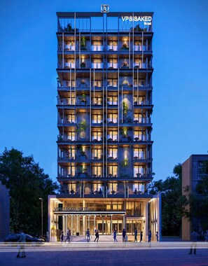 A multi-story hotel with a modern design, featuring balconies with plants and a well-lit entrance. - VP Sisaked Hotel (Vientiane)