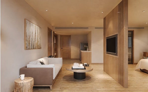 A modern hotel room with a sofa, coffee table, TV, and a wooden floor. - VP Sisaked Hotel (Vientiane)
