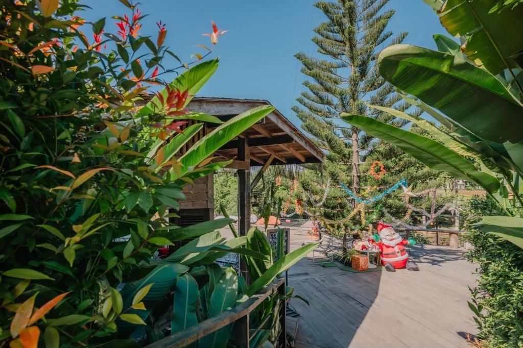 A wooden deck with a covered seating area, surrounded by lush tropical vegetation.