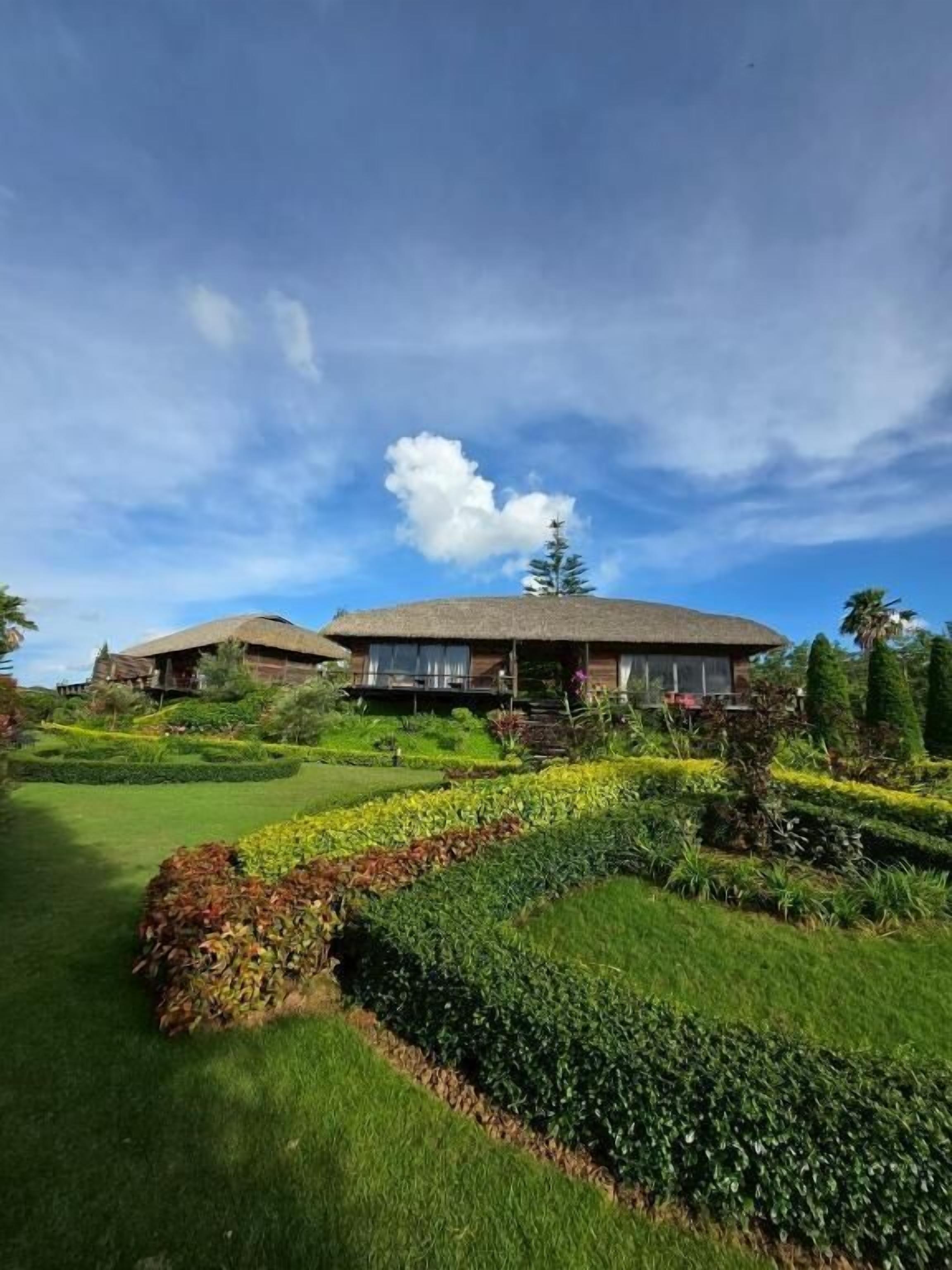 A large house with a well-maintained garden and a clear sky.
