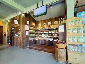 A store interior with wooden walls, a television screen, and shelves stocked with various products. - Arabica Khaokho (Khao Kho)