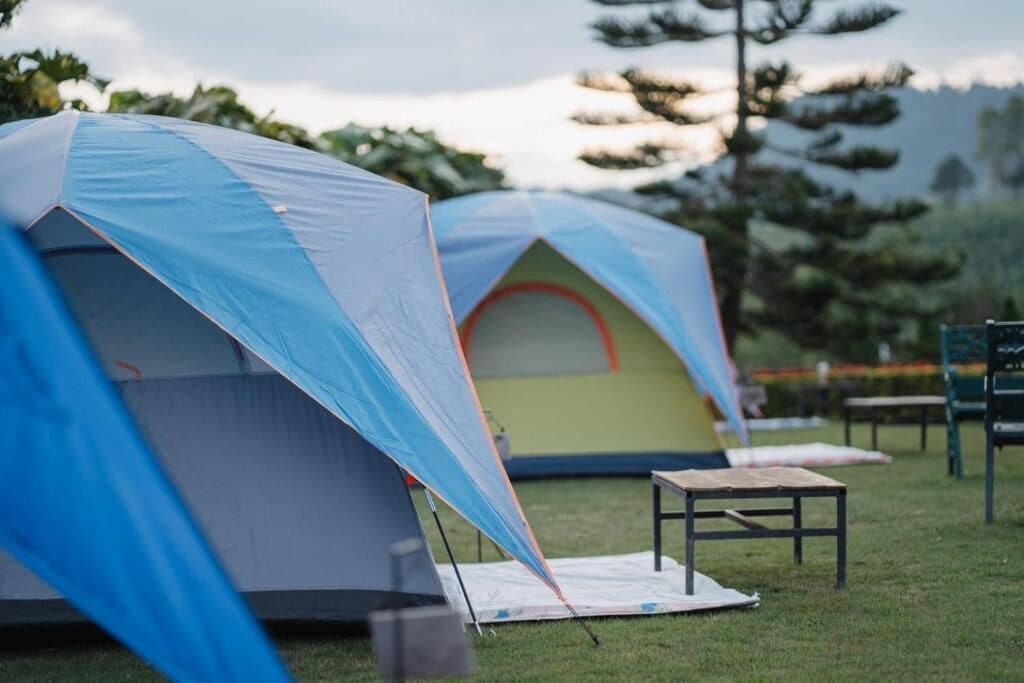 Un campamento con tiendas de campaña y una mesa.