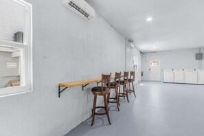 A conference room with a long table and four chairs, white walls, and a door with an exit sign. - Poolside Fun, Pickleball & Coastal Adventures Await in Fort Myers - Jefferson Palms 125-4 - Roelens (Fort Myers Beach)