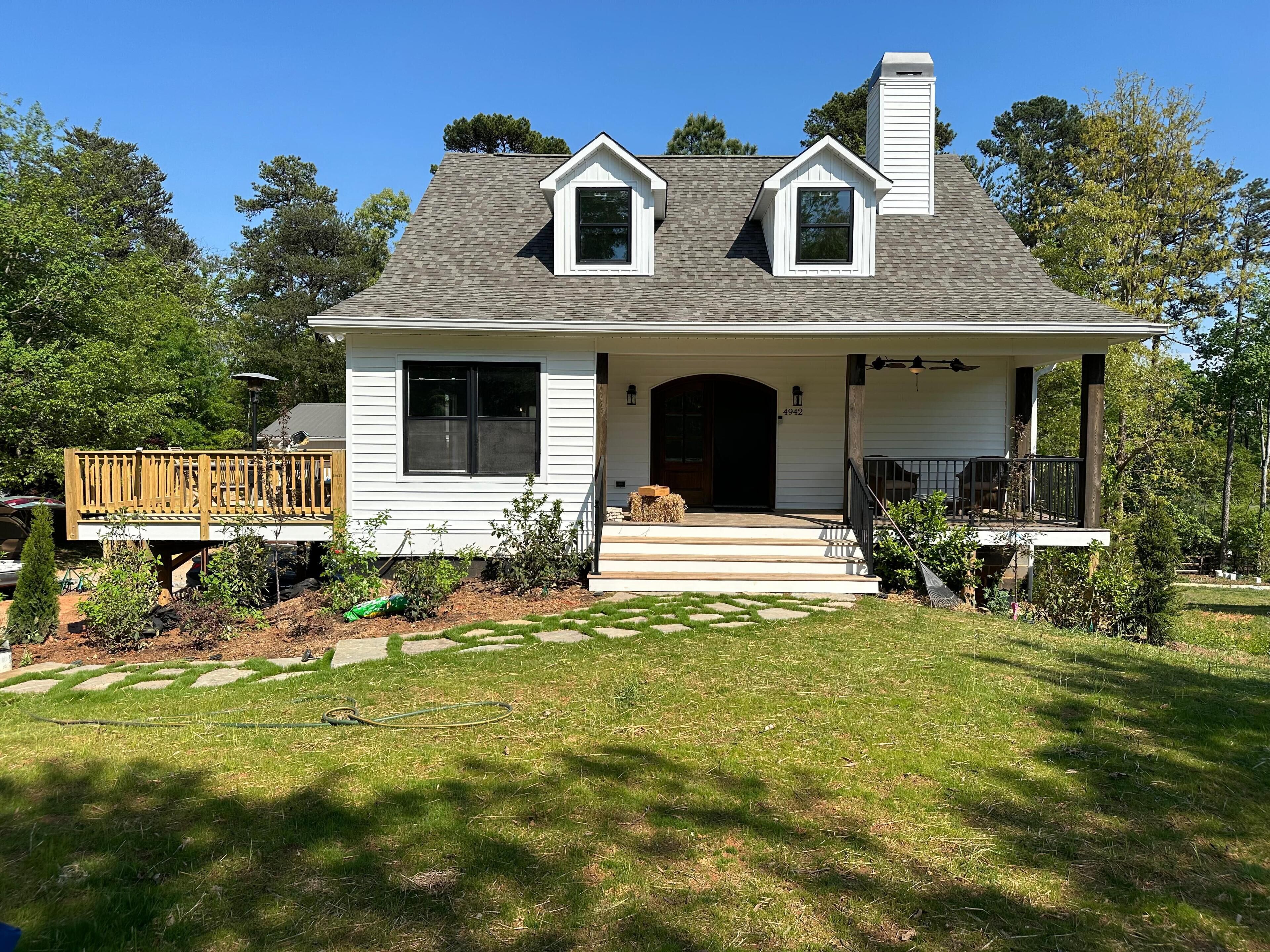A two-story house with a front porch, a chimney, and a mailbox.