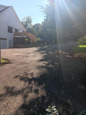 A gravel driveway leading to a building with a garage and a fenced yard. - Lake Norman 3 bed/bath cottage with private parking for cars with boat trailers (Lake Norman of Catawba)