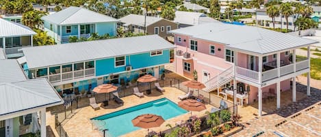 A resort with a swimming pool, outdoor seating, and a view of the surrounding area.