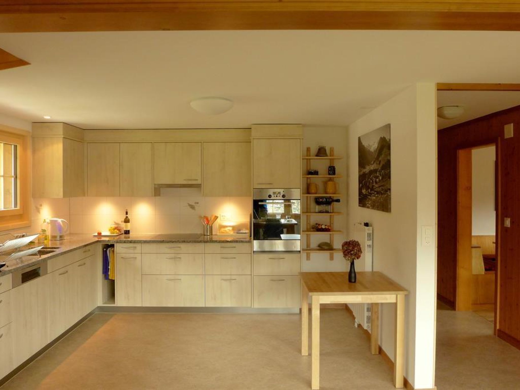 Una cocina moderna con armarios de madera, una isla central y un área de comedor con mesa y sillas.