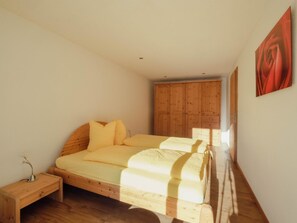 A bedroom with a wooden bed, a nightstand, and a wardrobe. - Chalet Bärgfride Appartement/Fewo, Dusche, WC, 1 Schlafraum 3-Zimmerwohnung by Interhome (Kandersteg)