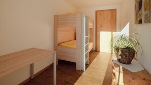 A compact room with a bunk bed, a desk, and a potted plant. - Chalet Bärgfride Appartement/Fewo, Dusche, WC, 1 Schlafraum 3-Zimmerwohnung by Interhome (Kandersteg)