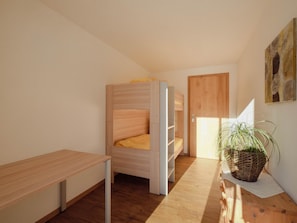 A compact room with a bunk bed, a desk, and a potted plant. - Chalet Bärgfride Appartement/Fewo, Dusche, WC, 1 Schlafraum 3-Zimmerwohnung by Interhome (Kandersteg)