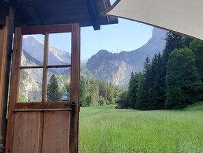 A wooden door leading to a room with a mountain view. - Schwendli Appartement/Fewo, Dusche, WC 3-Zimmerwohnung by Interhome (Kandersteg)