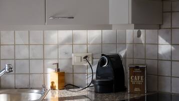 Un comptoir de cuisine avec une machine à café, une boîte en bois et un récipient en métal.