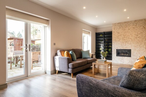 A modern living room with a grey sofa, a coffee table, and a fireplace.