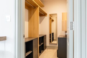 A walk-in closet with open shelving, a mirrored closet door, and a small vanity area. - Oxfordshire home Surrounded by Greenery (Bessels Leigh)