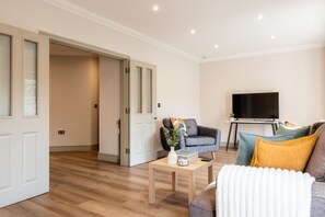 A living room with a sofa, a coffee table, and a television.
