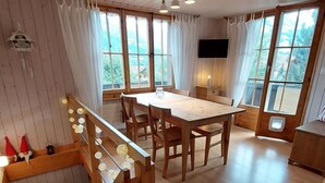 A wooden interior with a dining table, chairs, and a staircase. - Chalet Edelweiss Appartement/Fewo, Dusche, WC, 2 Schlafräume 3-Zimmerwohnung by Interhome (Frutigen)