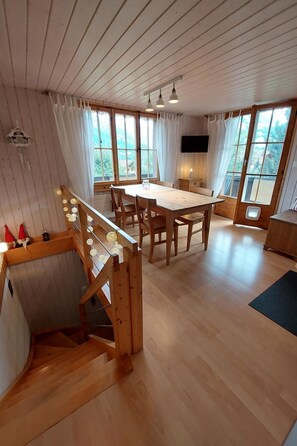 A wooden interior with a dining table, chairs, and a staircase. - Chalet Edelweiss Appartement/Fewo, Dusche, WC, 2 Schlafräume 3-Zimmerwohnung by Interhome (Frutigen)