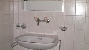 A bathroom with a white sink, a mirror above it, and a cabinet below. - Gehret Appartement/Fewo, Dusche, WC, 1 Schlafraum 2-Zimmerwohnung by Interhome (Adelboden)