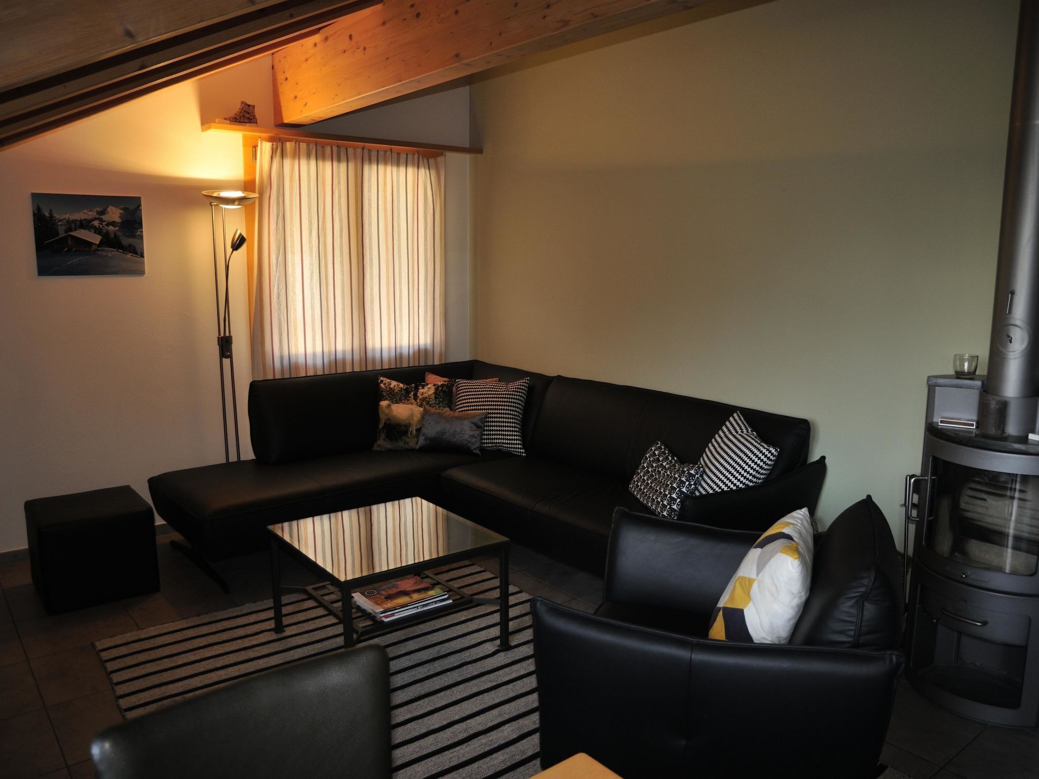 A modern living room with a sectional sofa, a glass coffee table, and a fireplace.