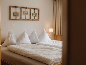 A hotel room with two beds, a wooden headboard, a wall-mounted picture frame, and a bedside lamp. - Gästehaus Alpengruss Ferienhaus, Dusche, WC, 1 Schlafraum Chalet by Interhome (Adelboden)