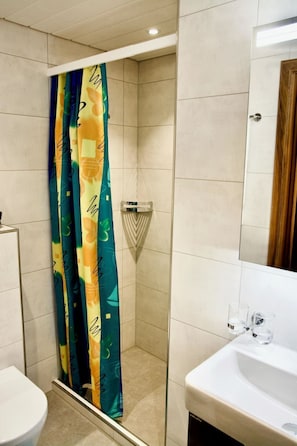 A bathroom with a shower, a toilet, and a sink. - Juwel 2 Appartement/Fewo, Bad, WC, 2 Schlafräume 3.5-Zimmerwohnung by Interhome (Adelboden)
