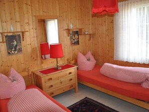 A room with two beds, a dresser, a mirror, and a window with curtains. - Juwel 2 Appartement/Fewo, Bad, WC, 2 Schlafräume 3.5-Zimmerwohnung by Interhome (Adelboden)