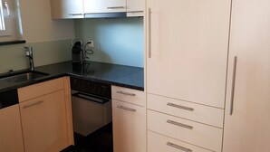Una cocina compacta equipada con lavavajillas, un lavabo y armarios.