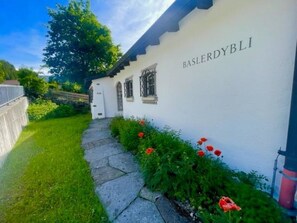 A building with a white exterior and the name 'BASLERDYBLI' on the side. - Baslerdybli Appartement/Fewo, Bad, WC, 3 Schlafräume 4-Zimmerwohnung by Interhome (Adelboden)