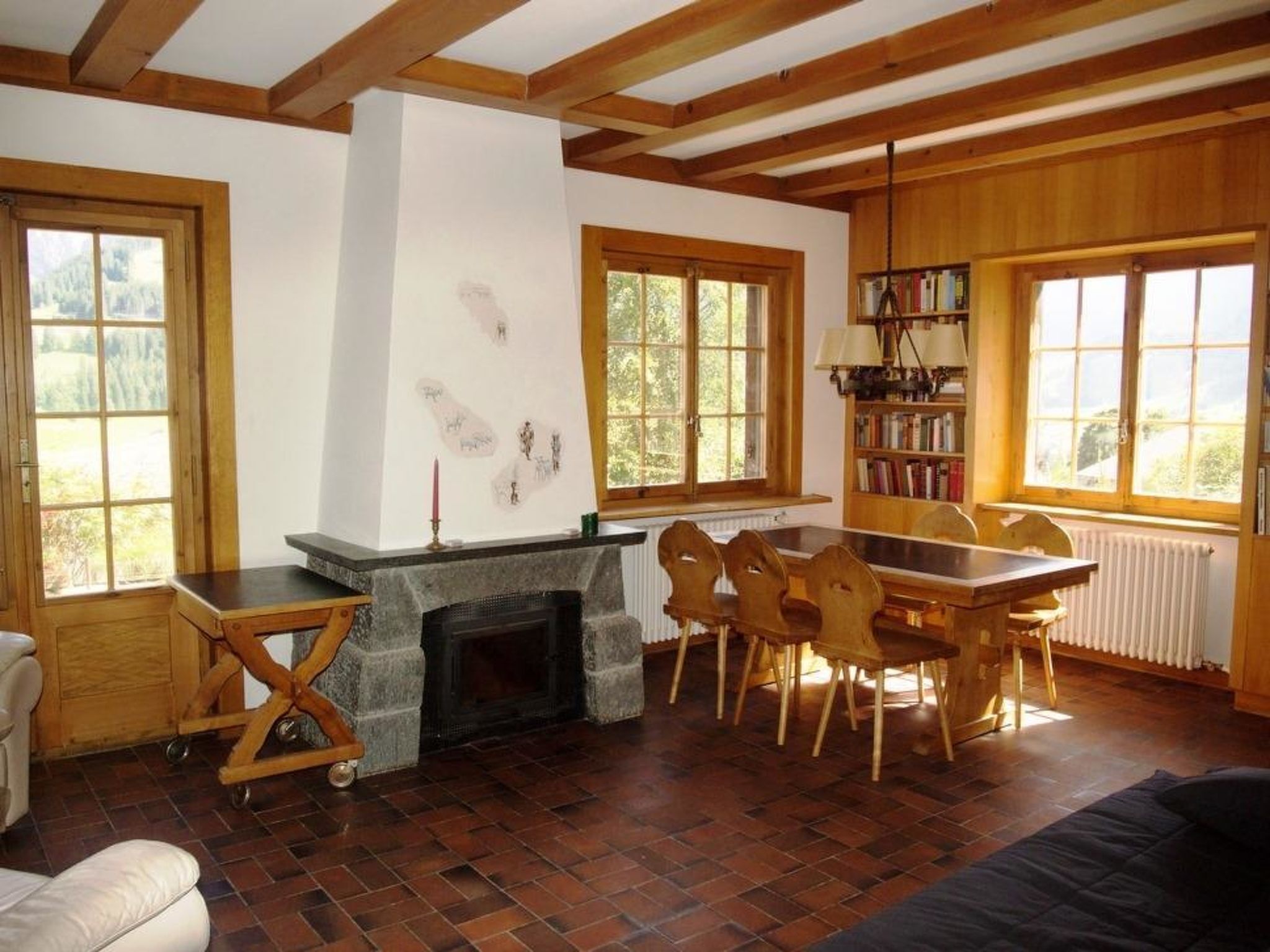 Una sala acogedora con chimenea, muebles de madera y ventanas amplias.