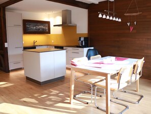 A modern kitchen with a central island, white cabinetry, and a hanging light fixture. - Rapunzel AP D22 Appartement/Fewo, Bad, WC, 2 Schlafräume 3-Zimmerwohnung by Interhome (Adelboden)