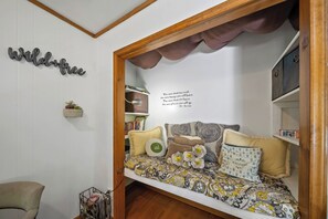 Eine gemütliche Leseecke mit integriertem Sitzbänklein, Bücherregal und einem motivierenden Zitat an der Wand.