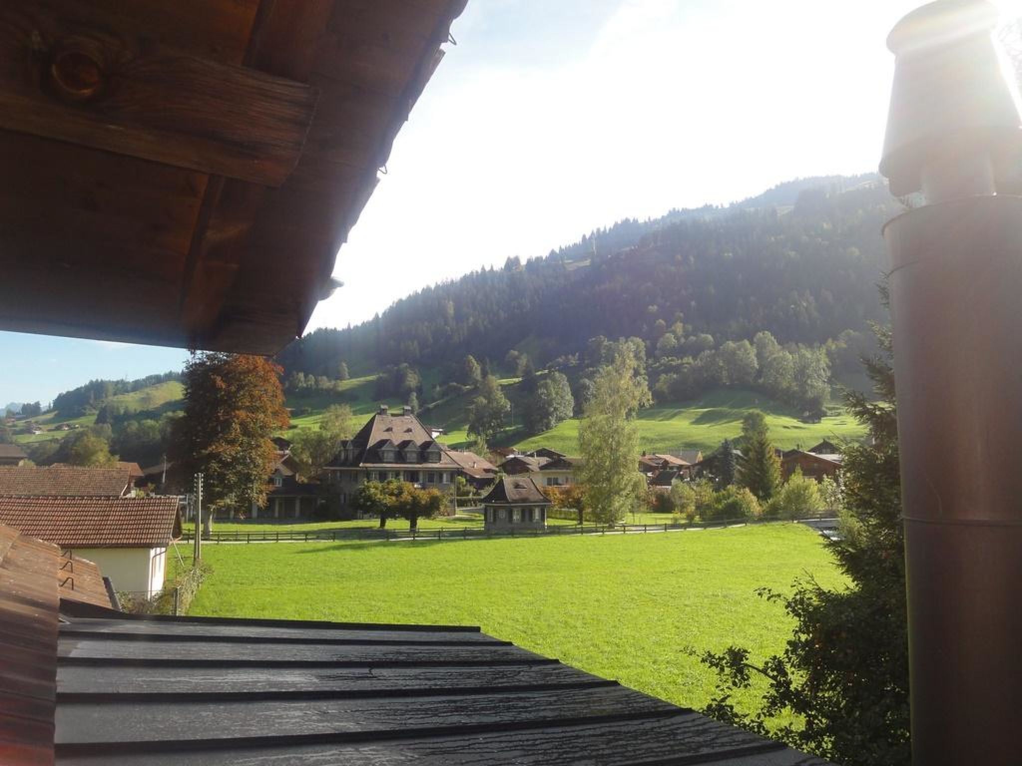 A view of a green field with a building in the background.