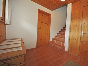 A wooden staircase leading to a door, a wooden bench, and a tiled floor. - Chalet Bodenweg Appartement/Fewo, Bad, WC, 1 Schlafraum 1-Zimmerwohnung by Interhome (Frutigen)