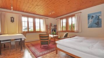 Une pièce avec un plafond en bois, un lit, un bureau avec des chaises et une bibliothèque.