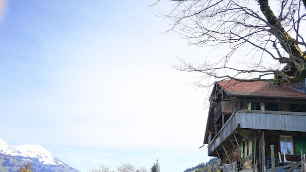 A wooden house with a balcony, surrounded by greenery and mountains in the background. - Weidhütte Wegscheide Hütte, Dusche, WC, 3 Schlafräume Wohnung 1. Stock by Interhome (Frutigen)