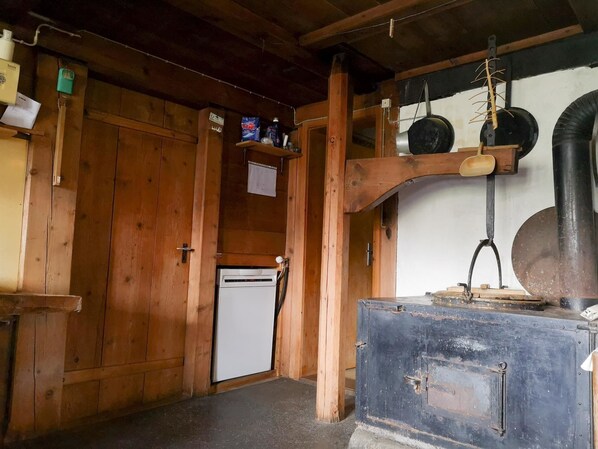 Un intérieur en bois comprenant un réfrigérateur, un évier et une armoire en métal.